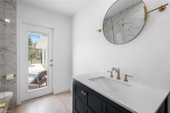 Full bath with vanity and light wood-style flooring
