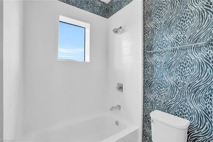 shared Bathroom featuring toilet and tiled shower / bath combo