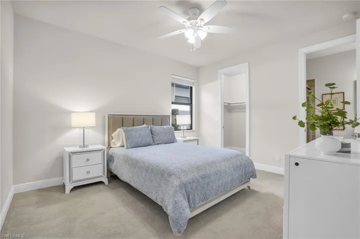 Bedroom featuring ceiling fan, a closet, carpet flooring, and a spacious closet