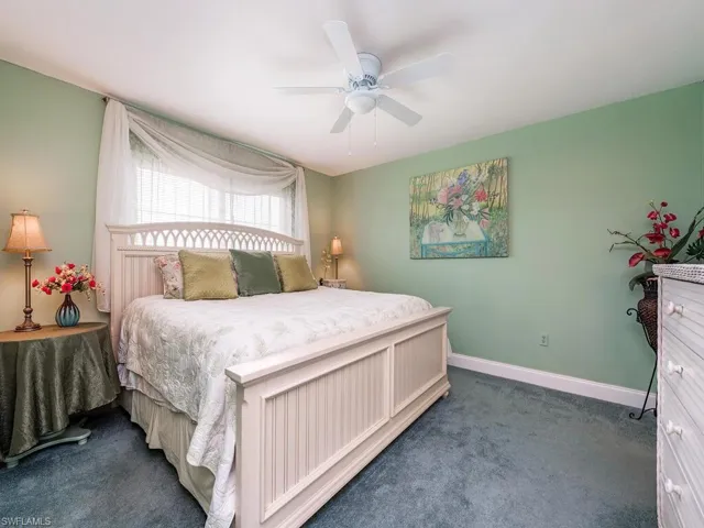 Bedroom with baseboards, carpet flooring, and a ceiling fan