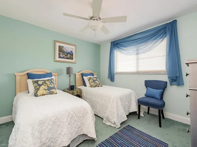 Carpeted bedroom featuring a ceiling fan and baseboards