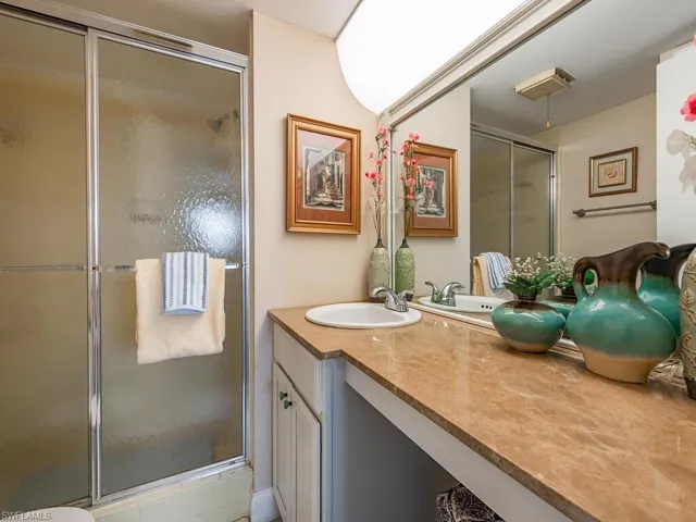 Full bath featuring a shower stall, visible vents, and vanity