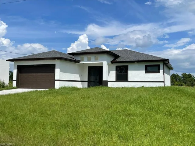 Prairie-style home with a garage and a front yard