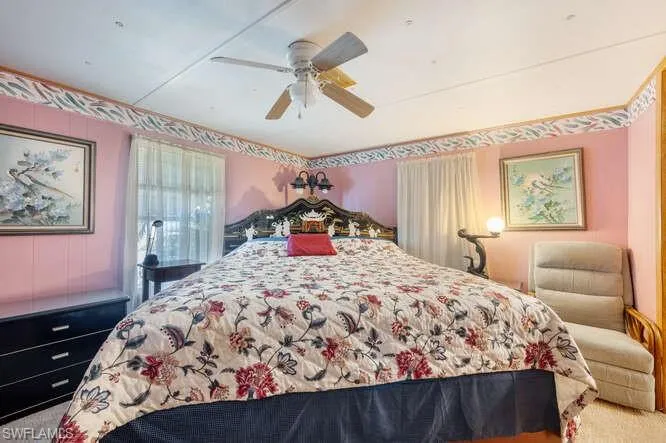 Carpeted bedroom featuring ceiling fan