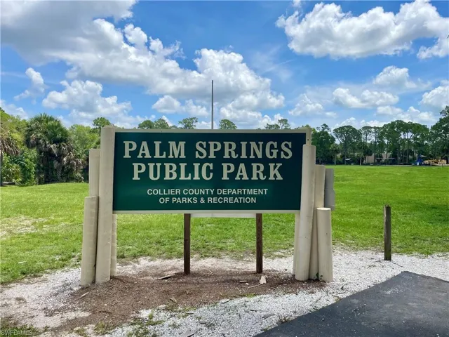 Community / neighborhood sign featuring a yard