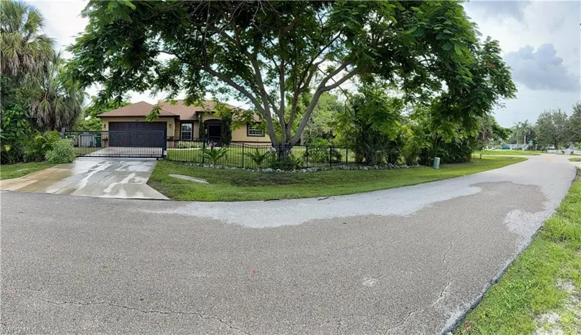 View of front of house featuring driveway, a fenced front yard, a garage, and stucco siding