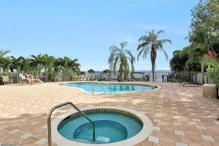View of pool with a hot tub and a patio area