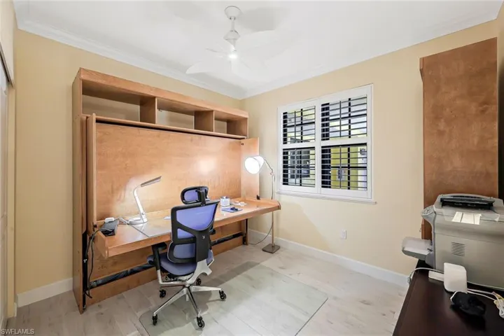 Office area with ceiling fan, light wood-type flooring, and ornamental molding