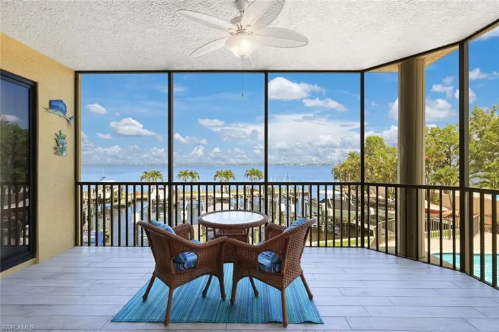 Sunroom with ceiling fan and a water view