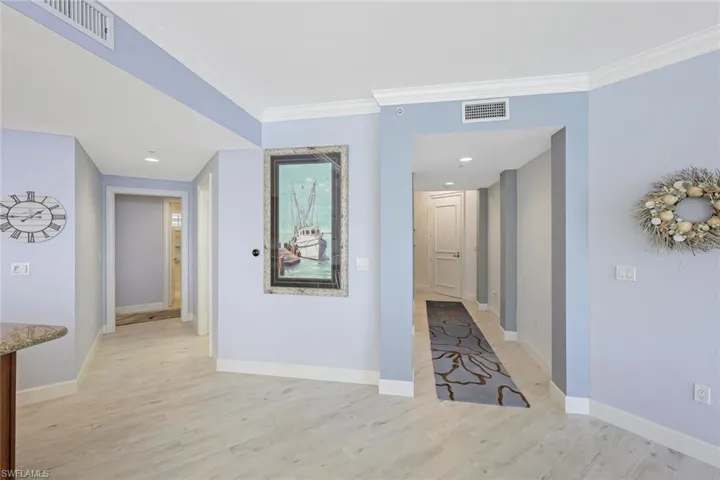 Hallway featuring ornamental molding and light wood-type flooring