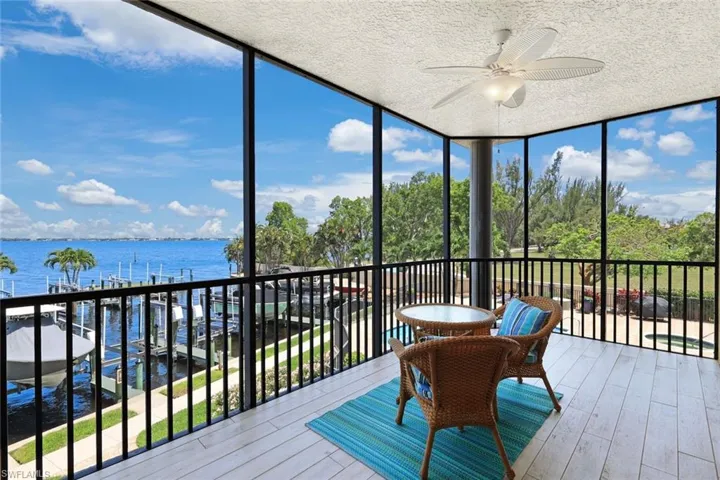 Sunroom / solarium with a water view and ceiling fan