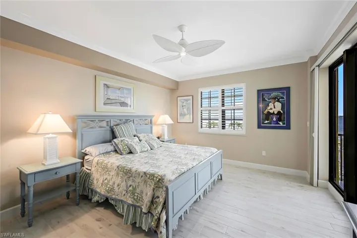 Bedroom with ceiling fan, ornamental molding, and light hardwood / wood-style floors
