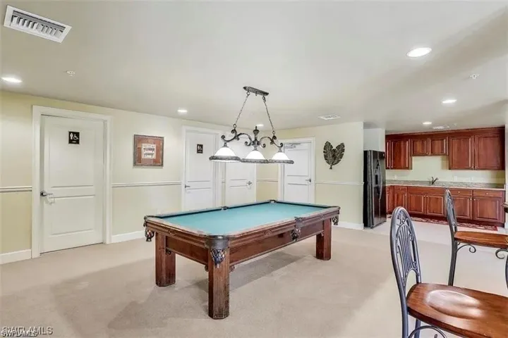 Recreation room featuring light carpet, sink, and billiards