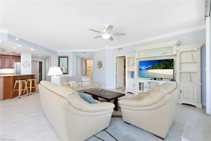 Living room featuring ornamental molding, ceiling fan, and light hardwood / wood-style flooring