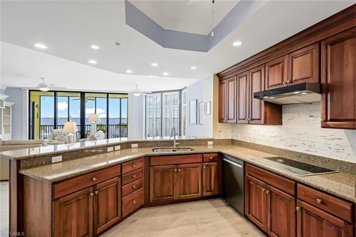 Kitchen with light wood-type flooring, sink, ceiling fan, and black electric cooktop