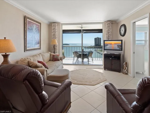 Tiled living area with healthy amount of natural light, crown molding, and expansive windows