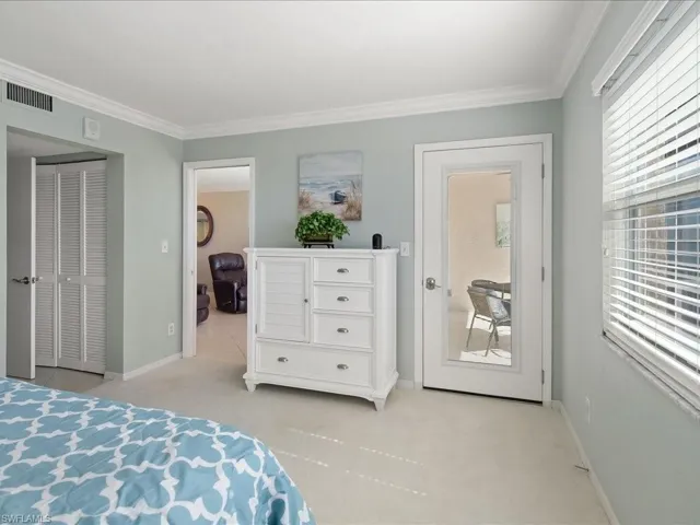 Bedroom with carpet floors, crown molding, and a closet