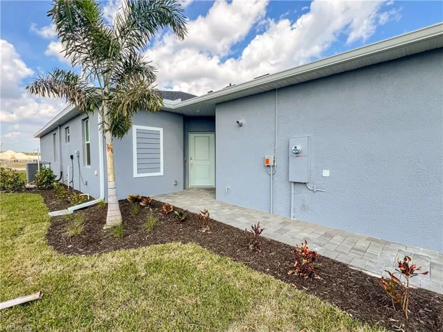 View of property exterior featuring stucco siding, a patio area, and a yard