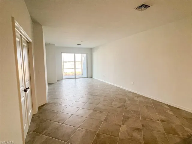 Empty room featuring baseboards and light tile patterned floors