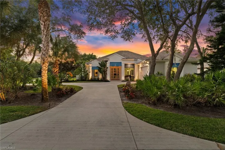 Lighting, landscape, and architecture come together for a warm welcome into this beautifully updated Naples retreat.