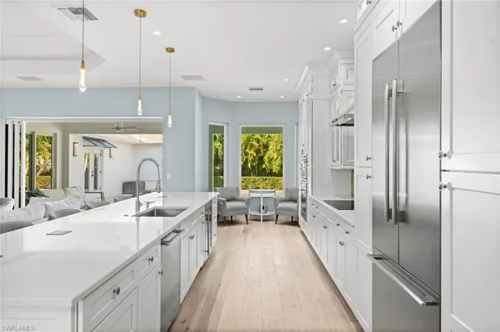 Quartz waterfall island, glass-front cabinetry, premium appliances, and endless counter space, a true heart-of-the-home.