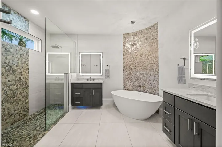Freestanding tub, pebble stone accents, dual vanities, and a walk-in shower designed for pure relaxation.