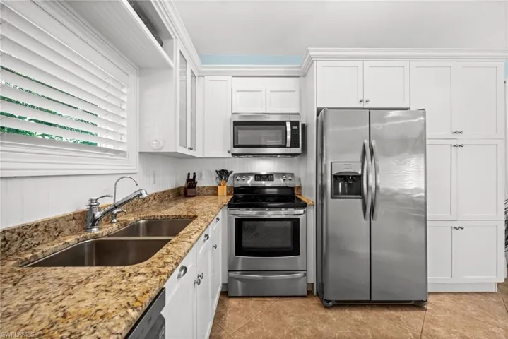 Stainless steel appliances, granite countertops, and ample storage make this guest kitchen fully functional.