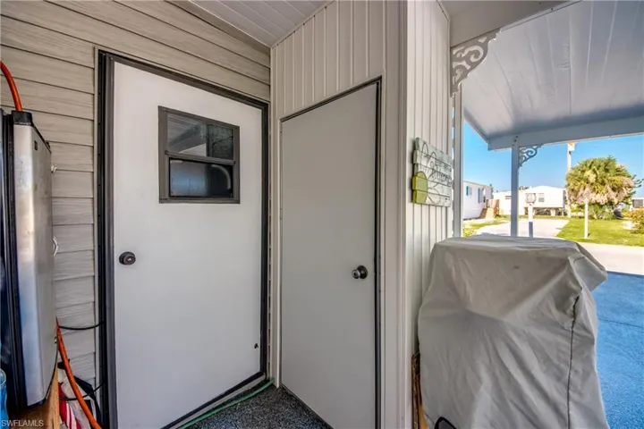 View of exterior entry featuring covered porch and board and batten siding