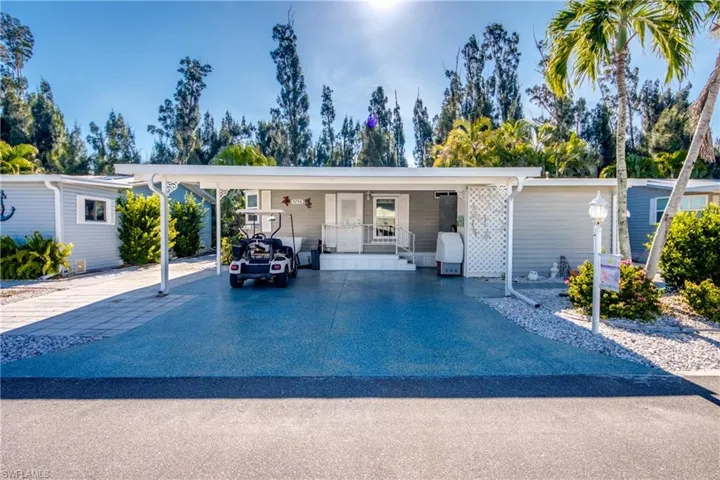 Manufactured / mobile home with driveway, a carport, and a porch