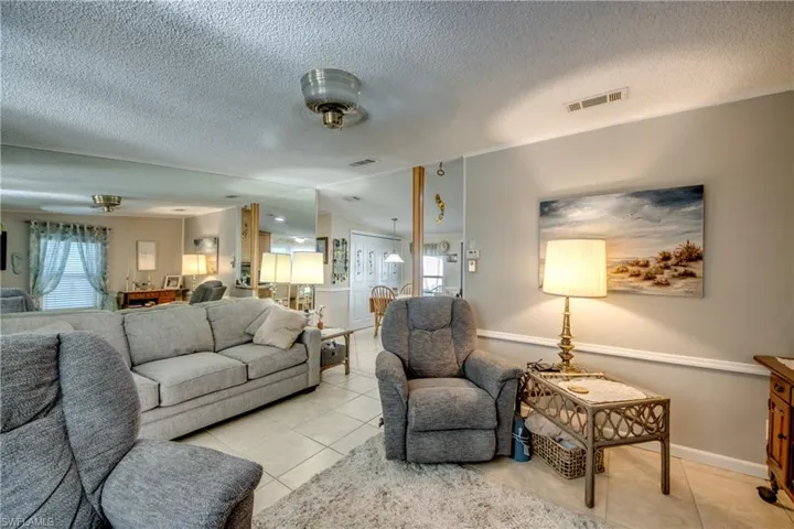 Living area featuring tile patterned flooring and a textured ceiling