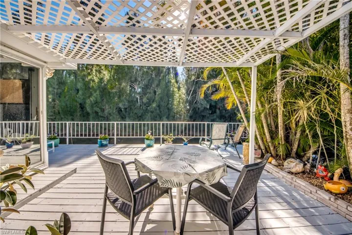 Wooden deck featuring outdoor dining space and view of scattered trees