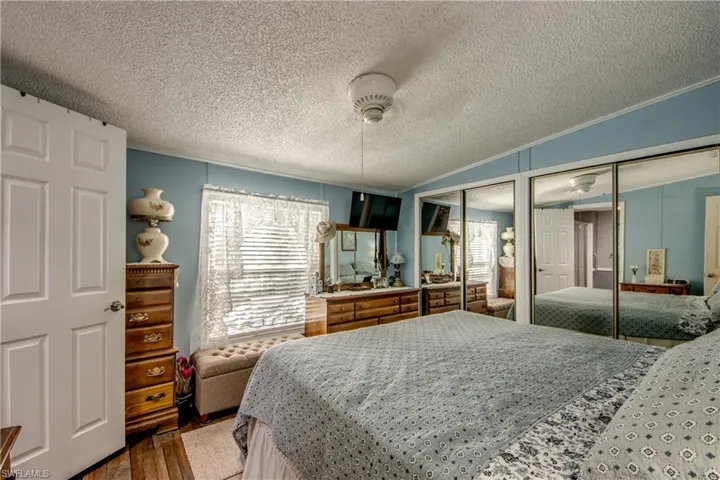 Bedroom featuring two closets, ceiling fan, and a textured ceiling