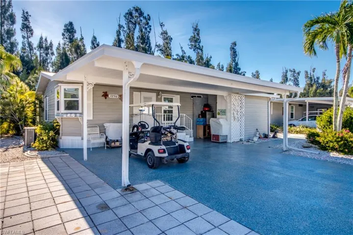 View of front of property with an attached carport, driveway, and a porch
