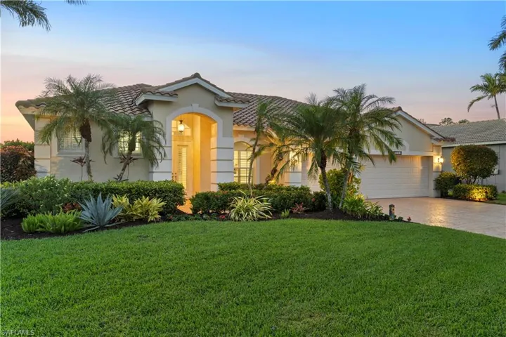 View of front of property featuring a garage and a yard
