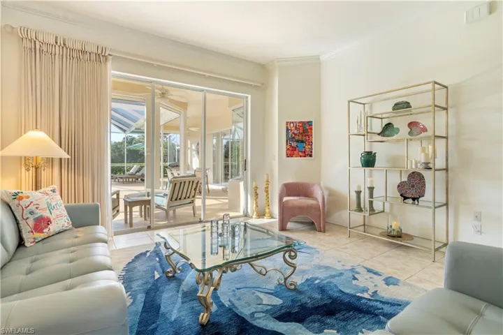 Tiled living room featuring ceiling fan and crown molding
