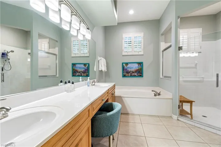 Bathroom featuring tile patterned floors, vanity, and independent shower and bath