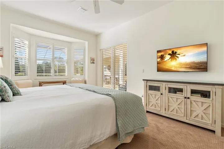 Carpeted bedroom featuring ceiling fan