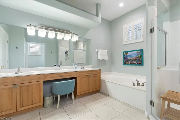 Bathroom featuring tile patterned floors, vanity, and separate shower and tub