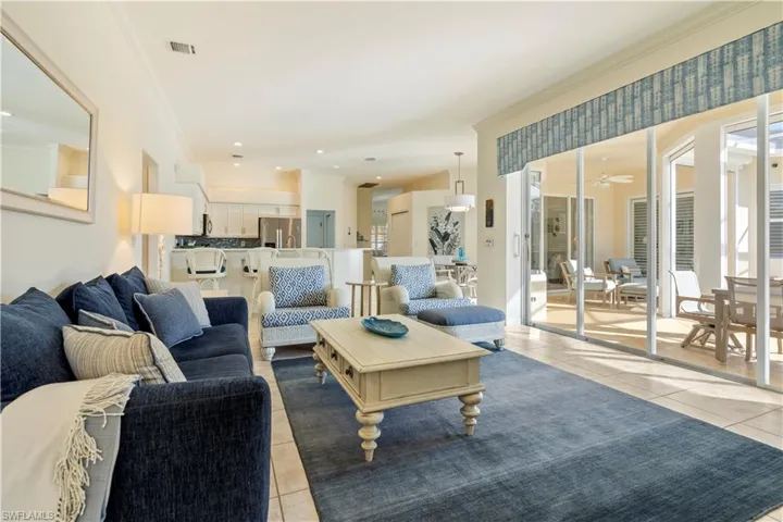 Tiled living room with crown molding and ceiling fan
