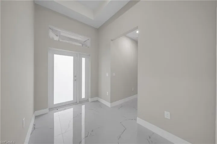 Entryway featuring baseboards and light marble finish floors