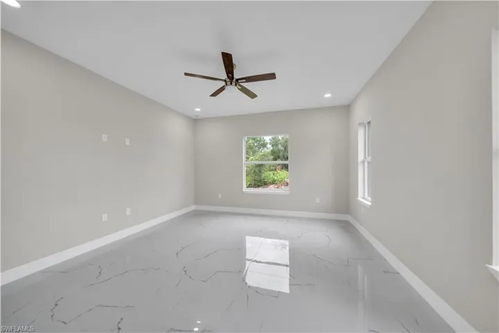 Unfurnished room featuring recessed lighting, light marble finish floors, and a ceiling fan