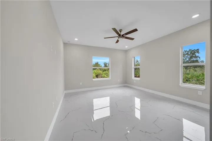 Unfurnished room with light marble finish floors, recessed lighting, and ceiling fan