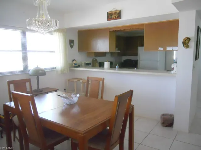 Dining area featuring light tile patterned floors and a chandelier