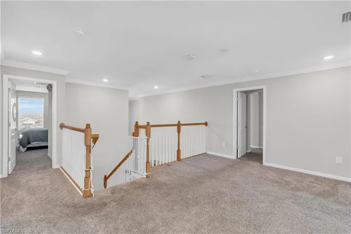 Empty room featuring light colored carpet and ornamental molding
