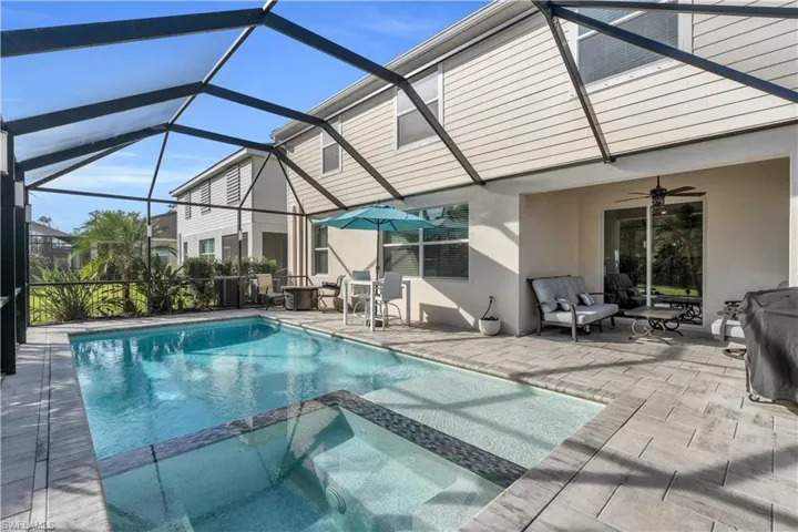 View of pool with an in ground hot tub, a lanai, a patio area, and ceiling fan