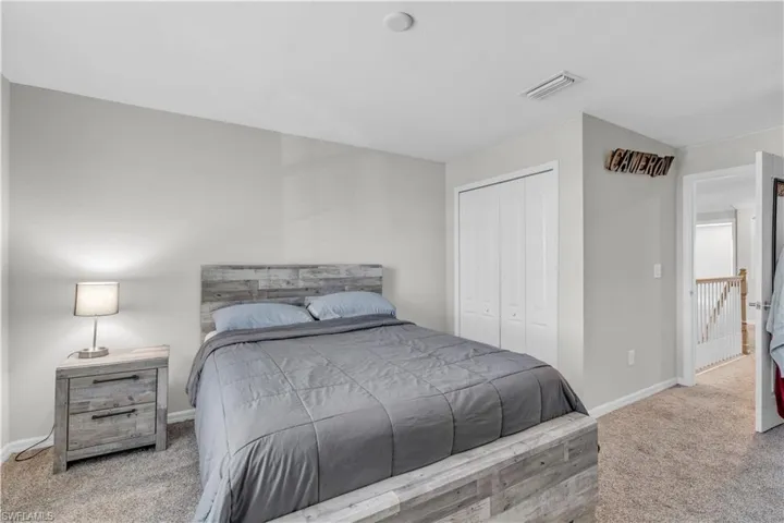 Bedroom featuring light colored carpet and a closet