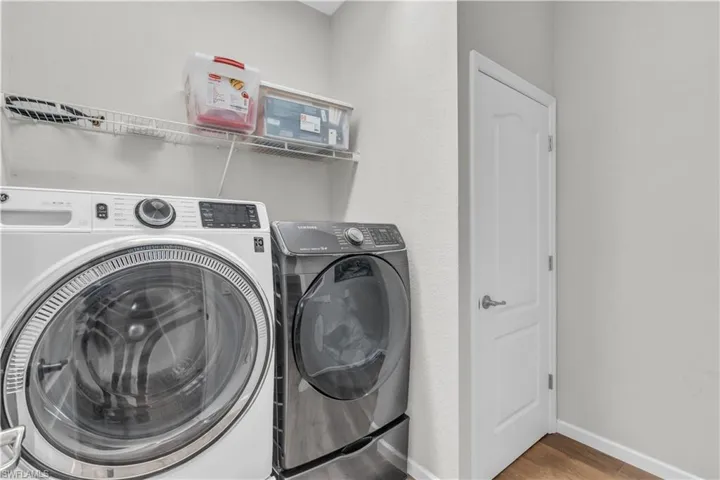 Clothes washing area with wood-type flooring and washing machine and clothes dryer