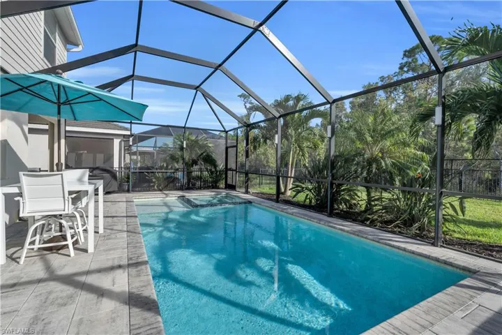 View of pool with a lanai and a patio