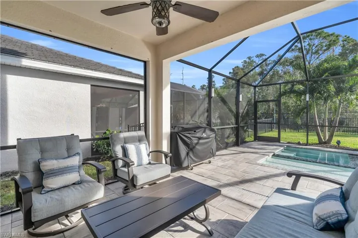 View of patio with a lanai, area for grilling, and ceiling fan
