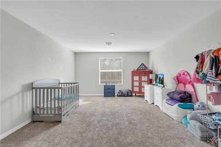 Bedroom with carpet floors and a nursery area